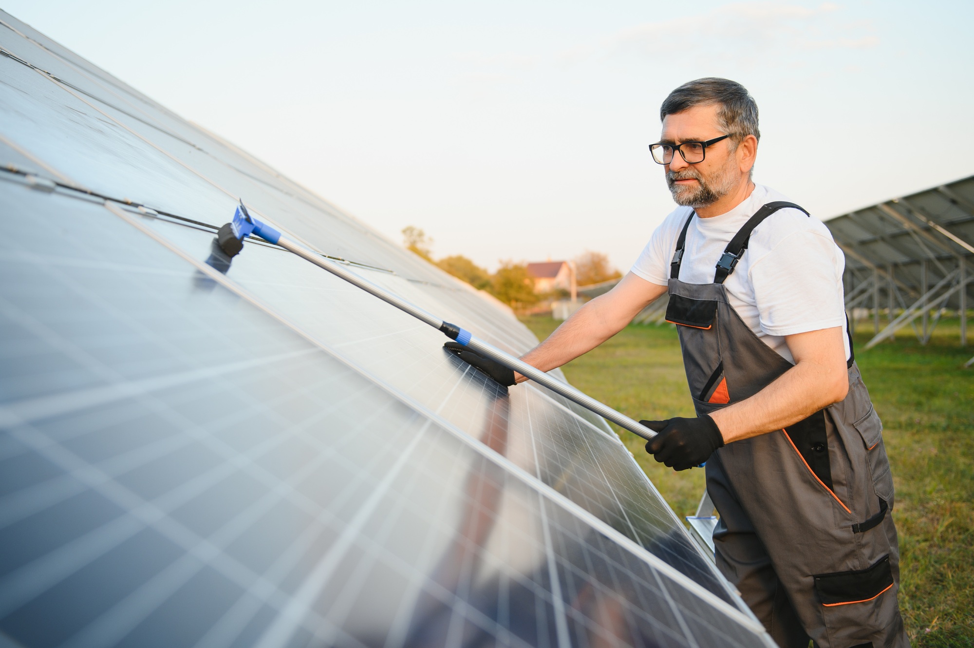 A handyman cleaning solar panels